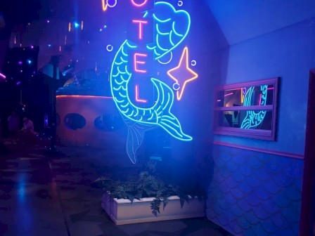 Neon sign of a mermaid with the word
