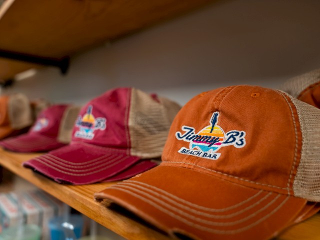 Baseball caps on a shelf, one with 