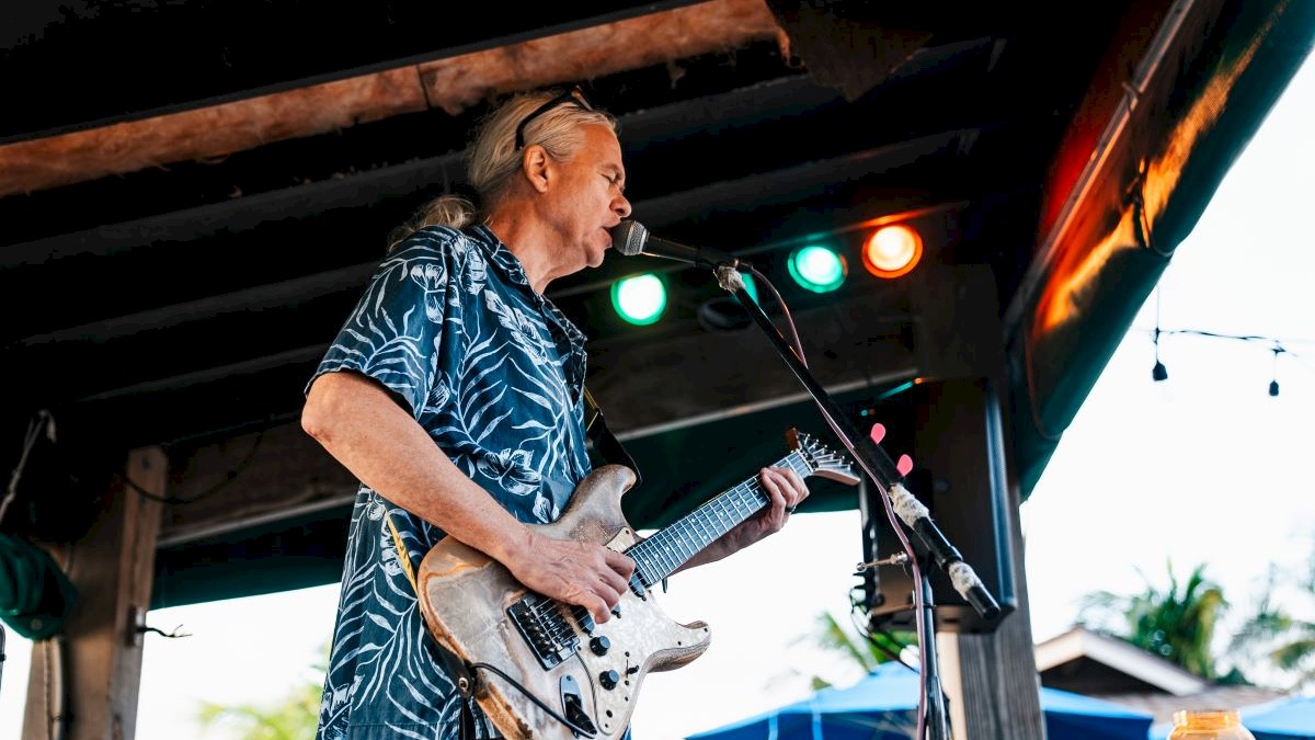 Musician playing an electric guitar on stage at Jimmy B's.