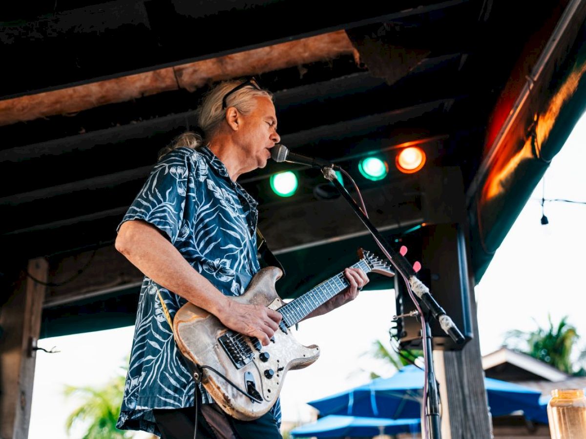 Musician playing an electric guitar on stage at Jimmy B's.